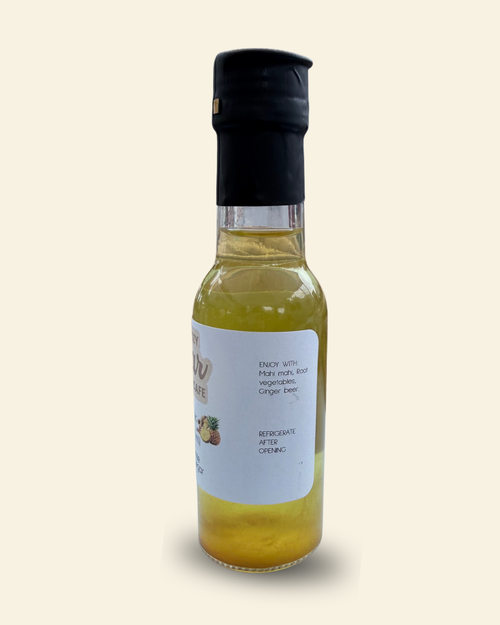 A bottle of Cozy Pear Cafe Glow Tonic, made from distilled white balsamic vinegar, featuring a white label and a black cap, set against a solid cream background.