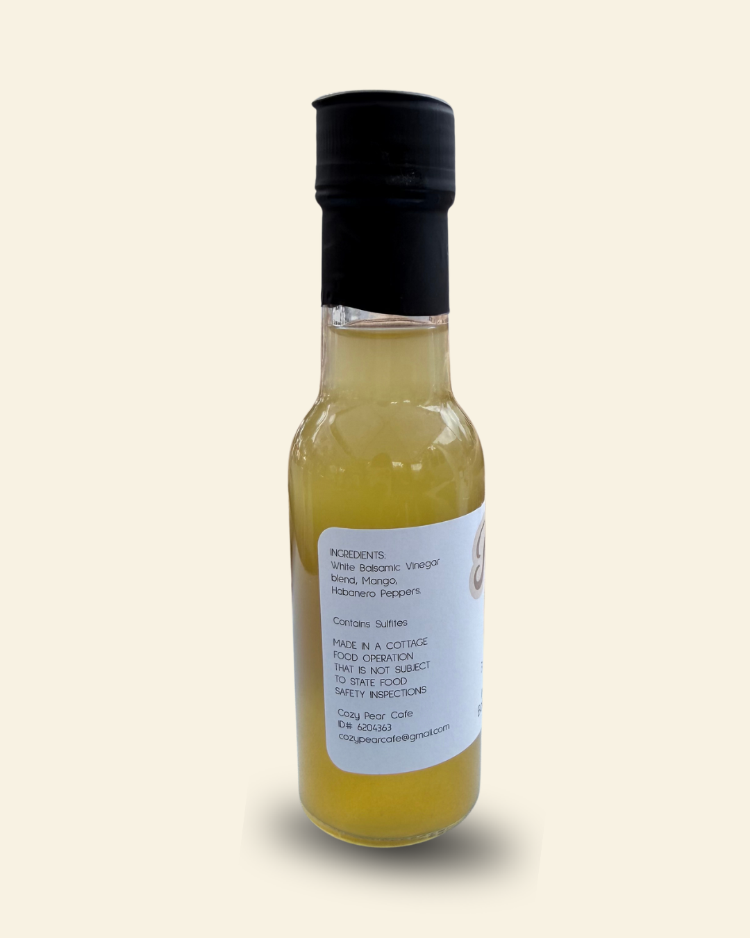 A 3 fl oz bottle of Cozy Pear Cafe Sol Spice Infused White Balsamic Vinegar, featuring a white label with brown script lettering and a black cap, set against a solid cream background.
